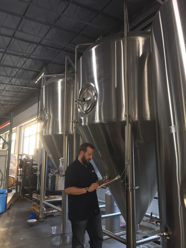 Dan checks in on the brewery's two forty-gallon fermenters. 