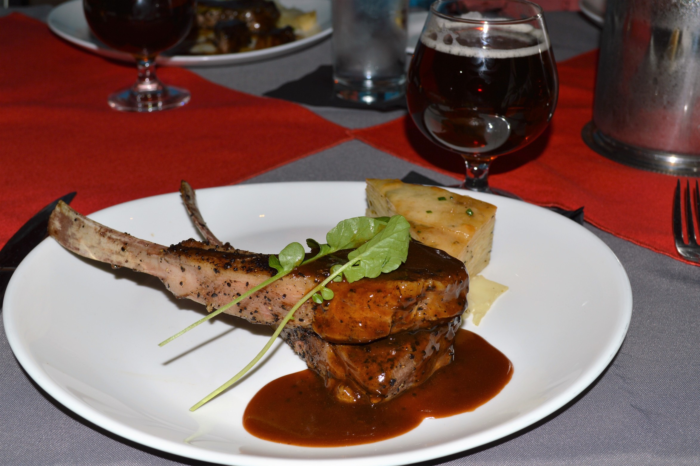 Expresso-encrusted Colorado lamb lollipops, white cheddar potato gratin, and water cress, with a 90 Schilling demi-glace.