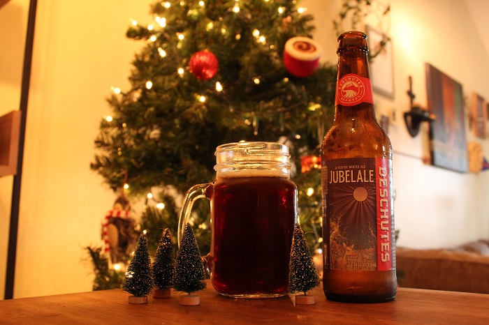 A full glass of Jubilale beer in front of a Christmas tree